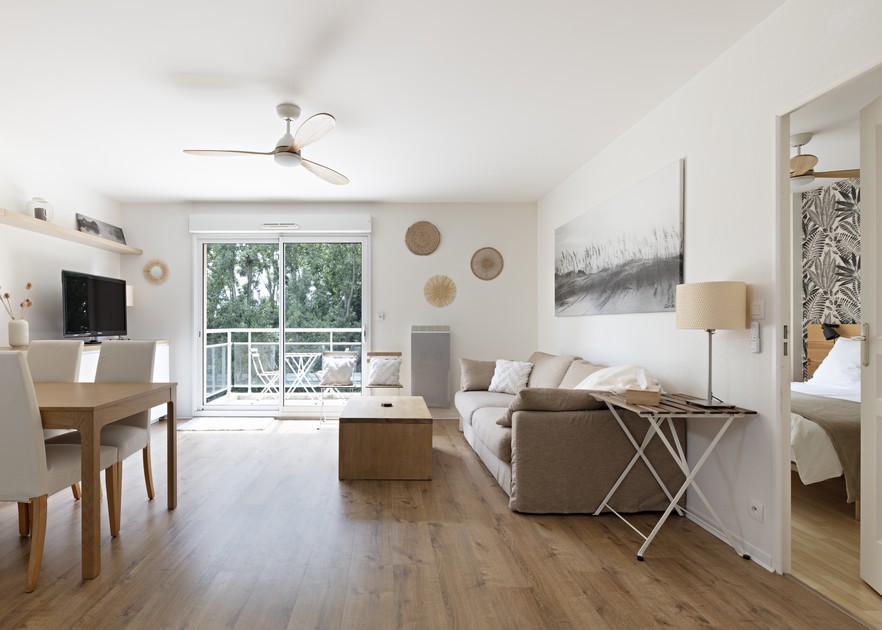 Décoration et agencement d'un appartement pour location saisonnière airbnb - pièce de vie, salon, coin repas, cuisine ouverte, blanc chaud, bois, beige